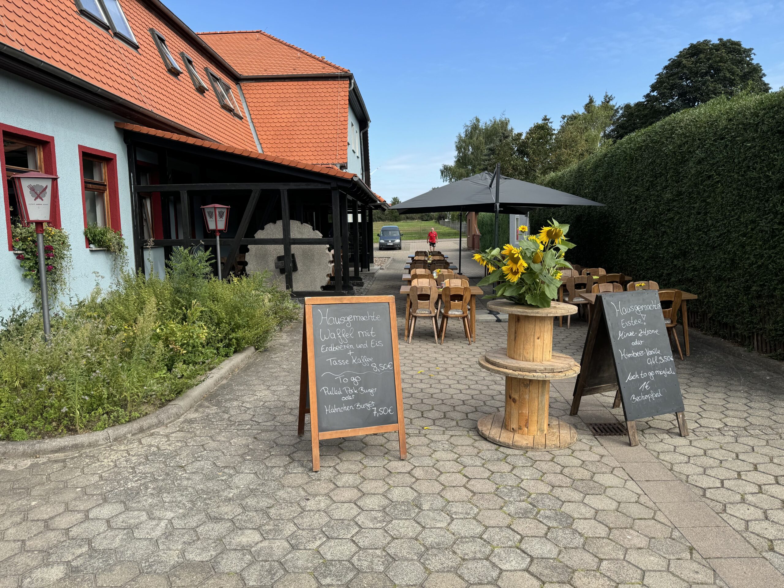 Eingang zu Gasthaus Neue Mühle. Zwei Kreidetafeln sind aufgestellt mit tagesaktuellem Menü.